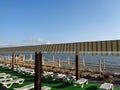 Rows of sunbeds on the beach, people relax at the seaside Royalty Free Stock Photo