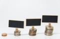 Rows of Thai baht coins and small black board for finance and banking concept with white background and selective focus
