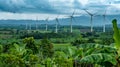 Rows of towering wind turbines overlooking a lush countryside providing clean sustainable energy for biofuel production. Royalty Free Stock Photo