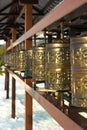 Traditional spinning prayer wheels at temple complex, asian culture of Hindu and Buddhist faith at local monastery