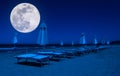 rows of umbrellas and deck chairs on the beach at night Royalty Free Stock Photo