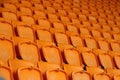 Rows of vacant orange fold up stadium seating
