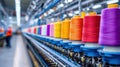 Rows of vibrant spools of thread in a textile factory, showcasing weaving machines and colorful threads, highlighting the textile Royalty Free Stock Photo