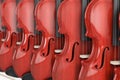 Rows of Vintage Red Wooden Violins for Sale Hanging on Shelf in Shop. 3d Rendering Royalty Free Stock Photo