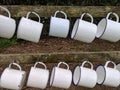 2 rows of white enamel camping mugs Royalty Free Stock Photo