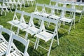 Rows of white folding chairs on lawn Royalty Free Stock Photo