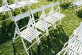 Rows of white folding chairs on lawn Royalty Free Stock Photo