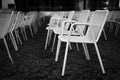 Rows of white metal garden chairs in front of an outdoor stage. Royalty Free Stock Photo