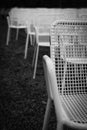 Rows of white metal garden chairs in front of an outdoor stage. Royalty Free Stock Photo