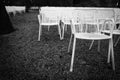 Rows of white metal garden chairs in front of an outdoor stage. Royalty Free Stock Photo