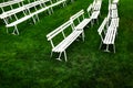 Rows of White Park Benches for Sitting on Green Grass Royalty Free Stock Photo