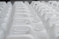 Rows of white plastic canisters ready to be filled with chemicals