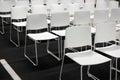 Rows of white plastic chairs for formal meetings, conference, lectures, graduation ceremonies. Room full of empty white chairs