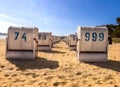 Rows of white wicker beach chairs on sandy beach under blue sky in a sunny day Royalty Free Stock Photo