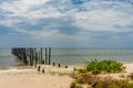 2 rows of wooden posts go out in to a calm paradise sea off of a Royalty Free Stock Photo