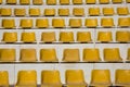 Rows of yellow empty seats in an outdoor bleacher