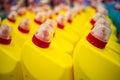 Rows of yellow plastic bottles with a red cap wirh household chemicals. close up, soft focus, backgound in blur