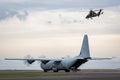 Royal Australian Air Force Lockheed Martin C-130J Hercules military cargo aircraft on the runway with an Army Eurocpter Tiger ARH Royalty Free Stock Photo