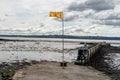 The Royal Banner of Scotland flag flying at a pier in the Firth of Forth in Culross, Scotland, UK. Royalty Free Stock Photo