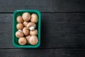 Royal champignons Parisian champignons on black wooden table background in plastic pack top view flat lay with space for