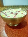 Royal Custard with lots of fruits like pomegranate,banana and mango served in a bronze bowl