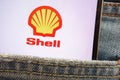 Royal Dutch Shell logo displayed on smartphone hidden in jeans pocket