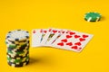 Royal Flush. Five playing cards - the poker royal flush hand. Poker chips on yellow. success in gambling. Royalty Free Stock Photo