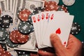 Royal flush in poker in the hands of the player on the background of gaming chips and money Royalty Free Stock Photo