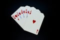 Royal flush straight flush of hearts cards in poker game against black background Royalty Free Stock Photo