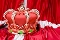 Royal golden crown with jewels on the Kingdom of Denmark flag background, 3D rendering