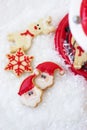 Royal icing santa cookies on artificial snow background with cop