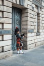 Royal Mile bagpipe singer near a building entrance