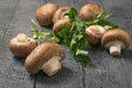 Royal mushrooms are scattered on a black wooden table with parsley leaves. Vegetarian food. Royalty Free Stock Photo