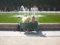 Royal Palace, Paris, France, August 17 2018: couple sitting on a double chair in front of a fountain