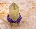 Royal purple Amethyst bead bracelet wrapped around Polished CITRINE single point on Natural Polished Petrified wood slab