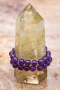 Royal purple Amethyst bead bracelet wrapped around Polished CITRINE single point on Natural Polished Petrified wood slab