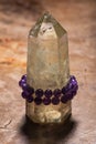 Royal purple Amethyst bead bracelet wrapped around Polished CITRINE single point on Natural Polished Petrified wood slab