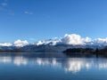 Roys bay at Wanaka in New Zealand with snow capped mountains and clouds in view