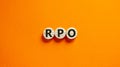 RPO symbol. Wooden circles with word `RPO - recruitment process outsourcing`. Beautiful orange background. Business and RPO -