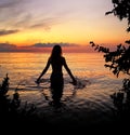 Rromantic young woman silhouette at sea on  orange sunset at sea summer evening nature landscape Royalty Free Stock Photo