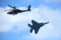 RSAF F-15SG fighter jet and Apache helicopter performing aerobatics at Singapore Airshow Royalty Free Stock Photo