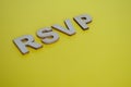 RSVP wooden letters representing Please respond on yellow background