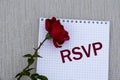 RSYP - words on a white sheet of paper with a red rose on a gray background