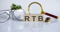 RTB concept on wooden cubes and flower ,glasses ,coins and magnifier on the white background Royalty Free Stock Photo