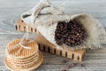 ruast arabic coffee beans in burlap with stack of dutch waffles on wooden table Royalty Free Stock Photo