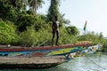 Unidentified local boy stands on the boat in front of the jungl