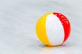 Rubber beach yellow white red ball lay on the gray wood floor