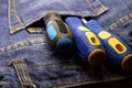 Rubber blue screwdriver handle, a hand tool for fixing screws lies on the background of workwear