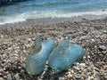 Rubber blue women`s slippers for swimming on a pebble beach