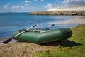 Rubber boat with fishing gear standing on a river near the sandy beach Royalty Free Stock Photo